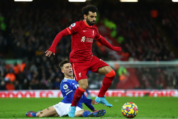 Mohamed Salah jumps over an oncoming tackle