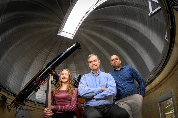 Lily Kettler, Professor Joaquin Viera and Kedar Phadke inside an astronomical observatory.